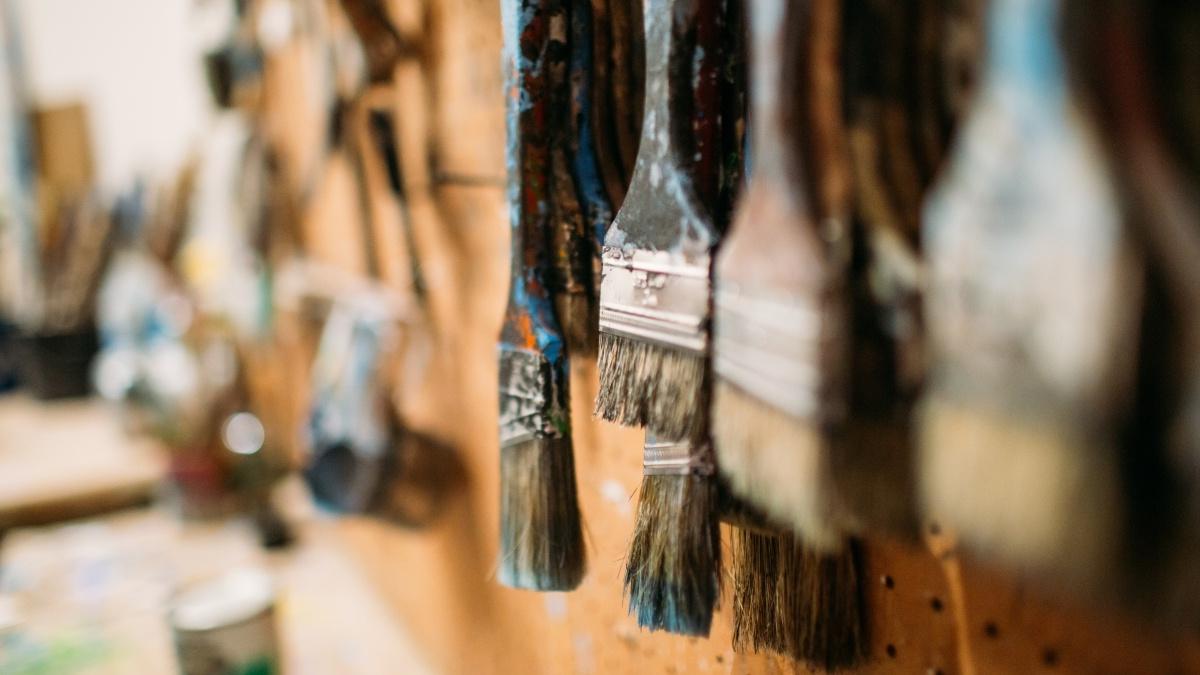 paint brushes hang on a wall in the art studio